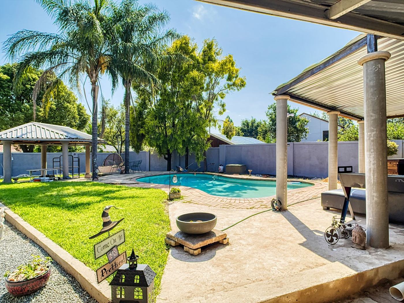 Villa garden with lawn, palms and pool